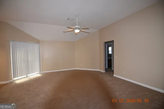 a view of an empty room with a ceiling fan