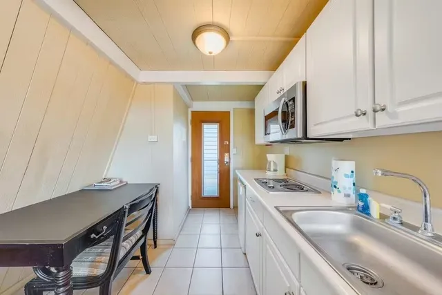 a kitchen that has a sink a stove and a microwave