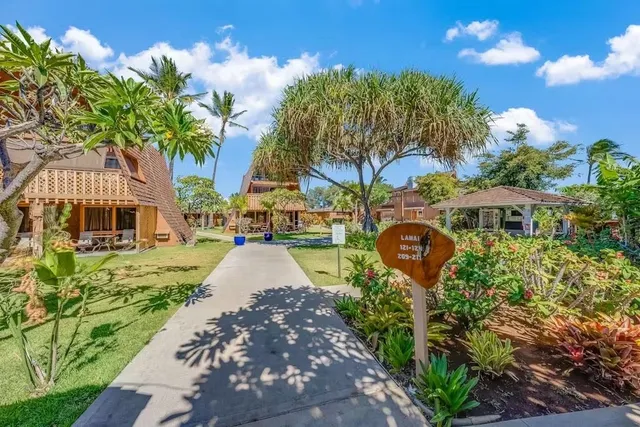 a front view of a house with a yard and fountain in middle