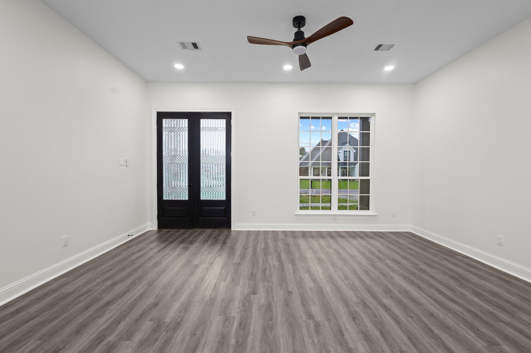 5250 HIghlander Drive Orange, TX 77630 - Photo 3 of 20 an empty room with wooden floor ceiling fan and windows