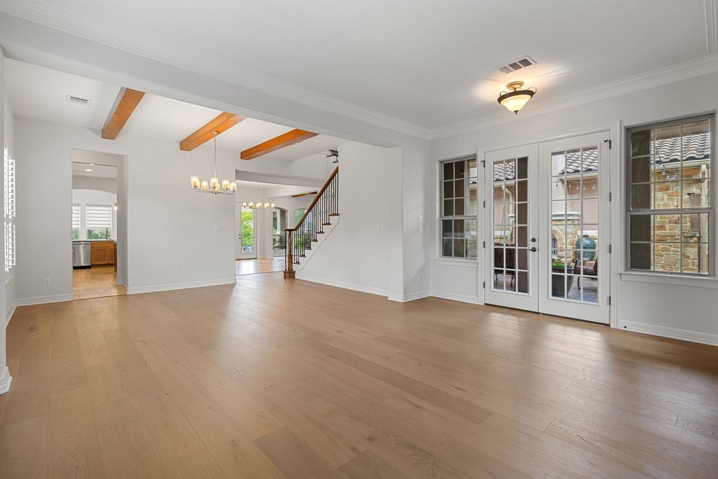 109 Largo Cove Austin, TX 78734 - Photo 18 of 40 Blonde hardwood floors extend across this naturally illuminated living space, complemented by a prominent staircase.