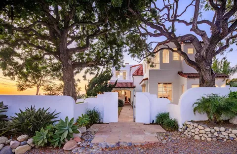 a front view of a house with a tree