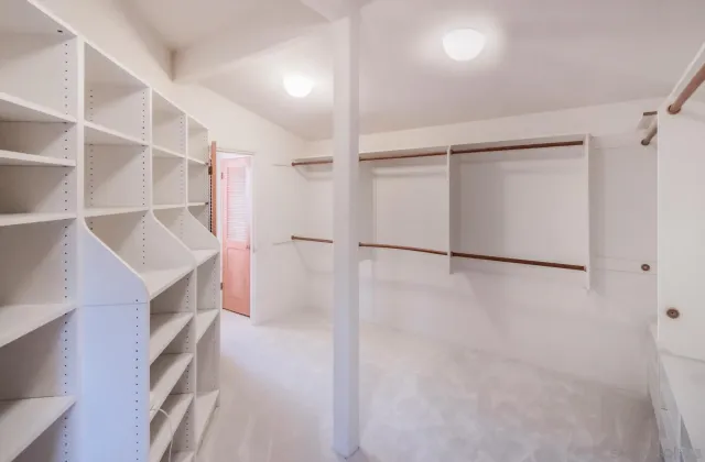a view of walk in closet with empty racks