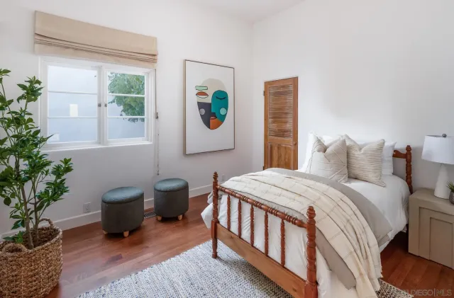 a bedroom with a balcony a bed and a potted plant