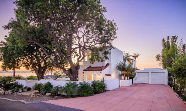 front view of a house with a yard and potted plants