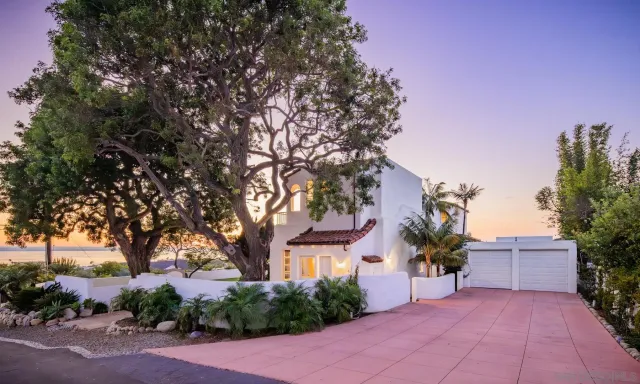 front view of a house with a yard and potted plants