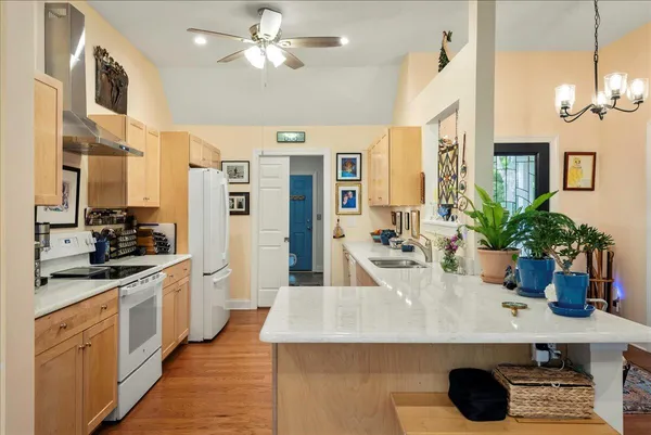 a kitchen with stainless steel appliances kitchen island granite countertop a table and chairs in it