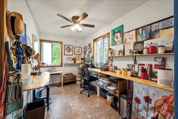 a view of a workspace with furniture and a window