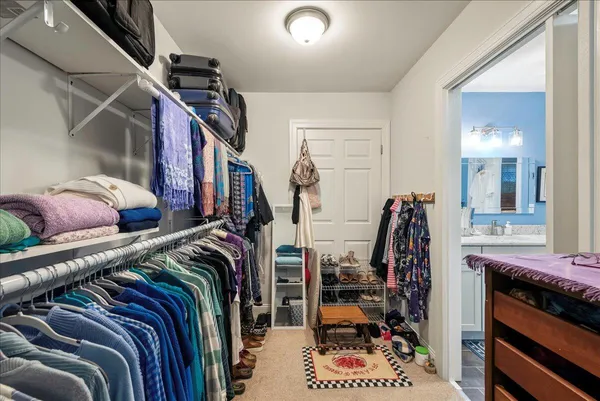 a view of walk in closet with clothes and shoes