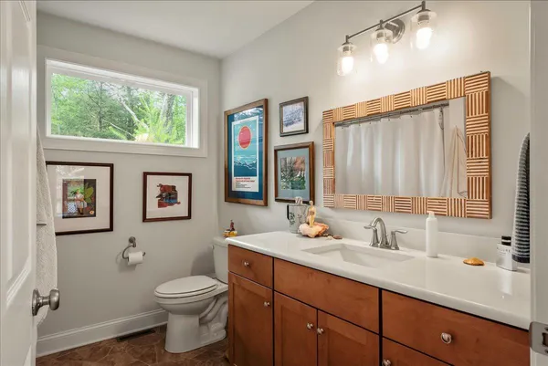a bathroom with a toilet a sink and a large mirror