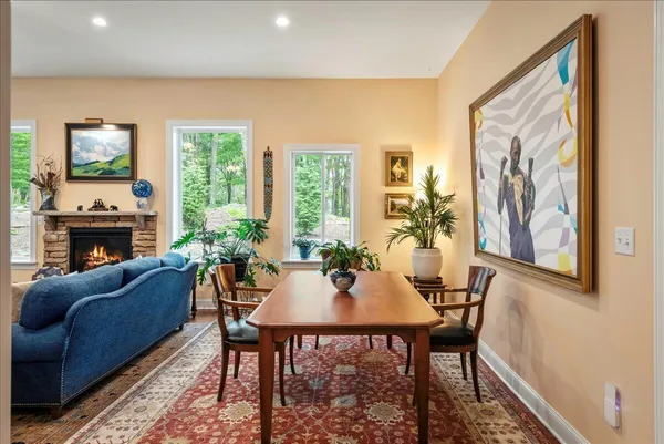a dining room with furniture a fireplace and wooden floor