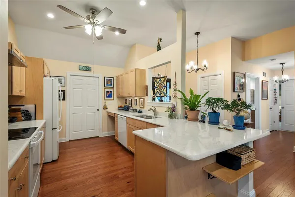 a kitchen with stainless steel appliances kitchen island granite countertop a stove a sink and a refrigerator