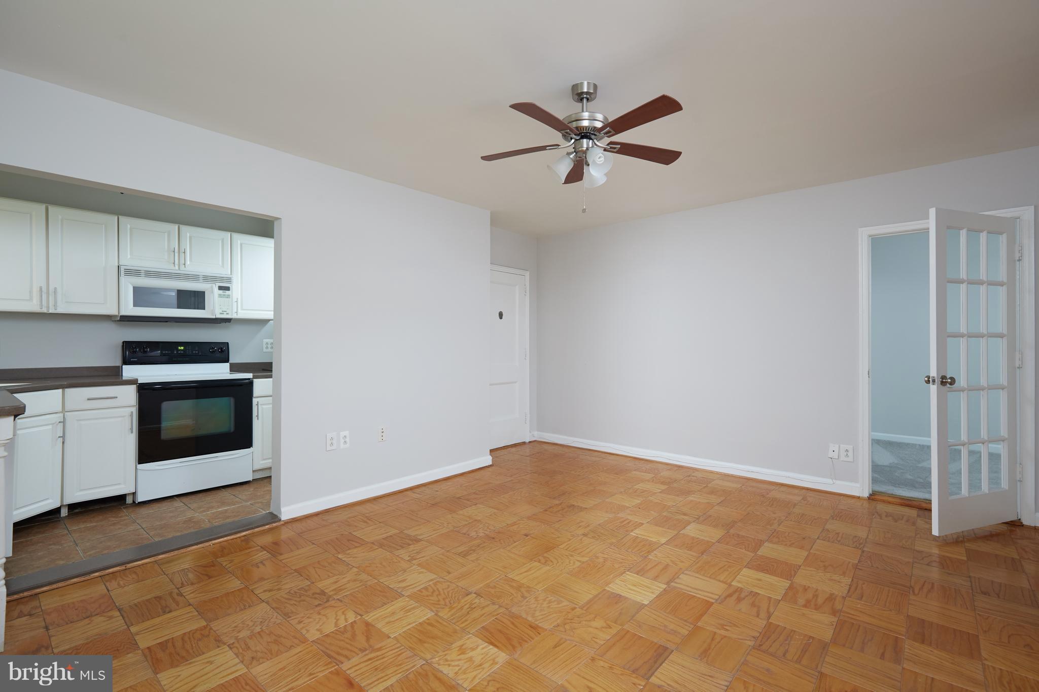 4004 Beecher Street Northwest, Unit 102 Washington, DC 20007 - Photo 2 of 24 a view of a kitchen with a stove cabinets and wooden floor