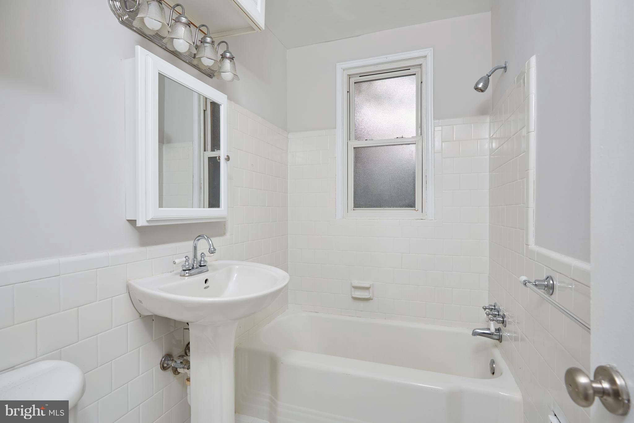 4004 Beecher Street Northwest, Unit 102 Washington, DC 20007 - Photo 13 of 24 a bathroom with a sink bathtub and shower