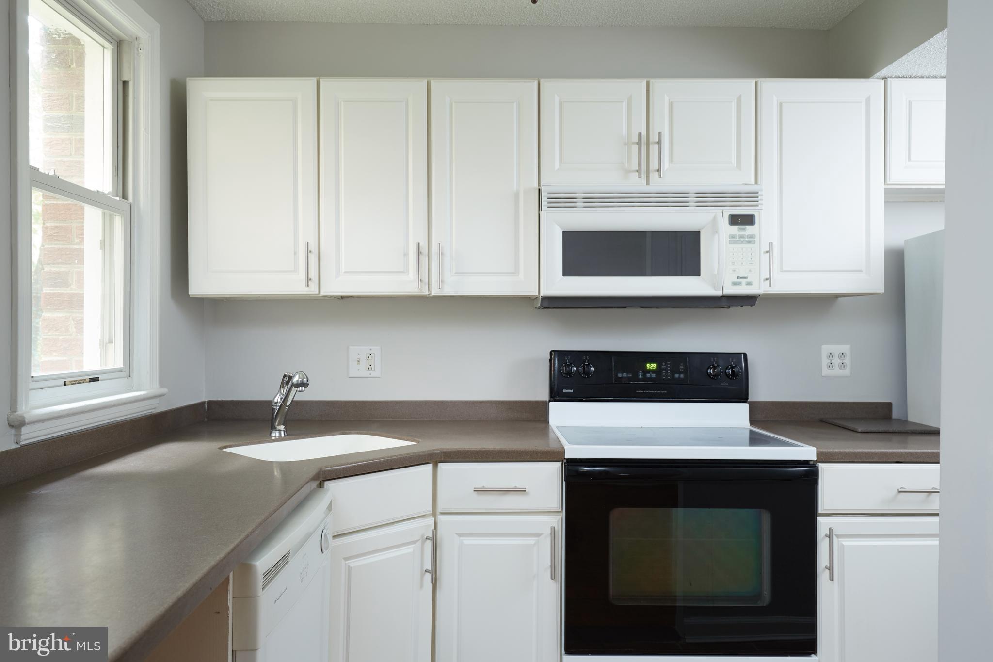 4004 Beecher Street Northwest, Unit 102 Washington, DC 20007 - Photo 6 of 24 a kitchen with granite countertop white cabinets and a stove