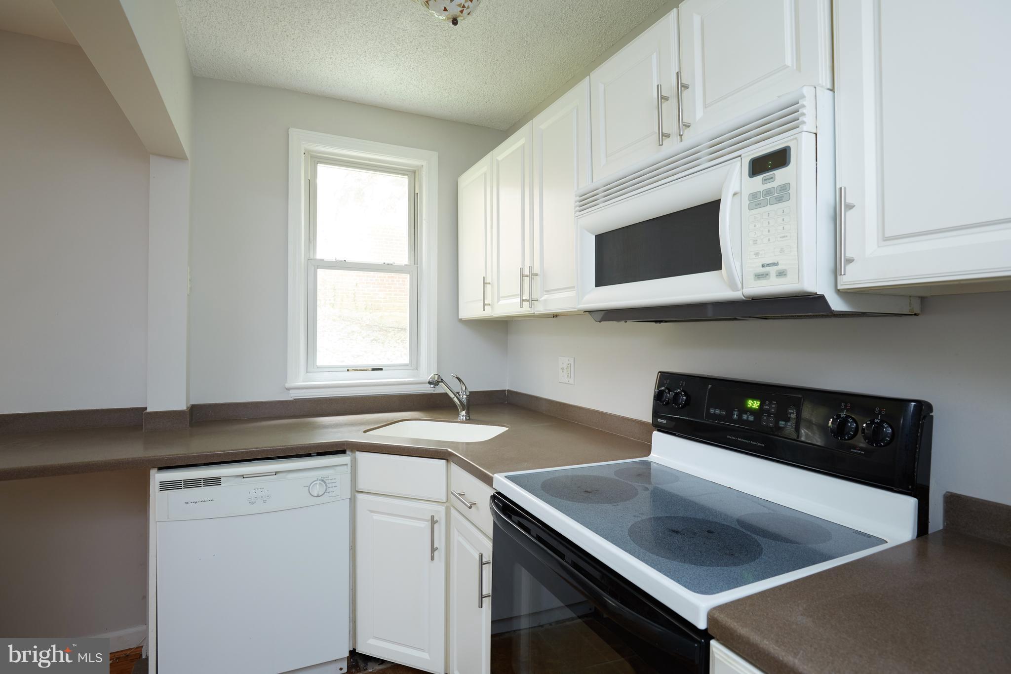 4004 Beecher Street Northwest, Unit 102 Washington, DC 20007 - Photo 8 of 24 a kitchen with stainless steel appliances white cabinets and a granite counter tops