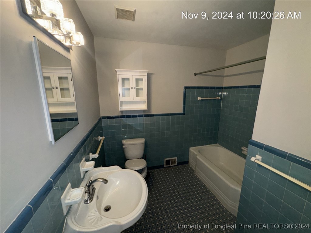 1429 Pine Valley Loop Fayetteville, NC 28305 - Photo 26 of 27 a bathroom with a toilet a sink and mirror