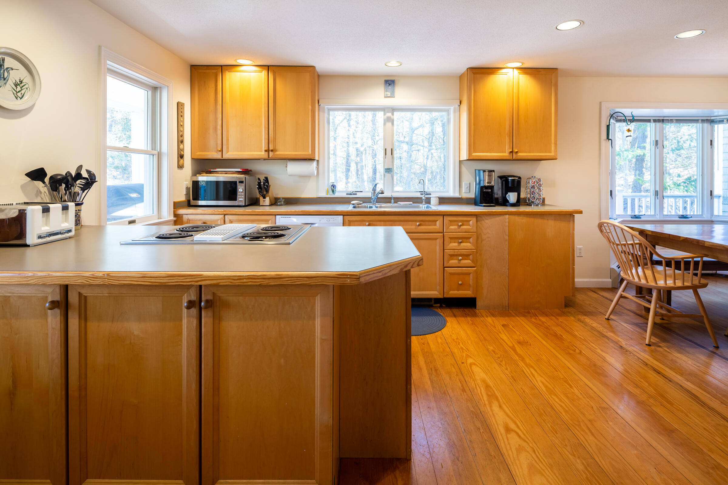 40 Chestnut Drive Orleans, MA 02653 - Photo 15 of 40 a kitchen with stainless steel appliances granite countertop sink stove and white cabinets with wooden floor