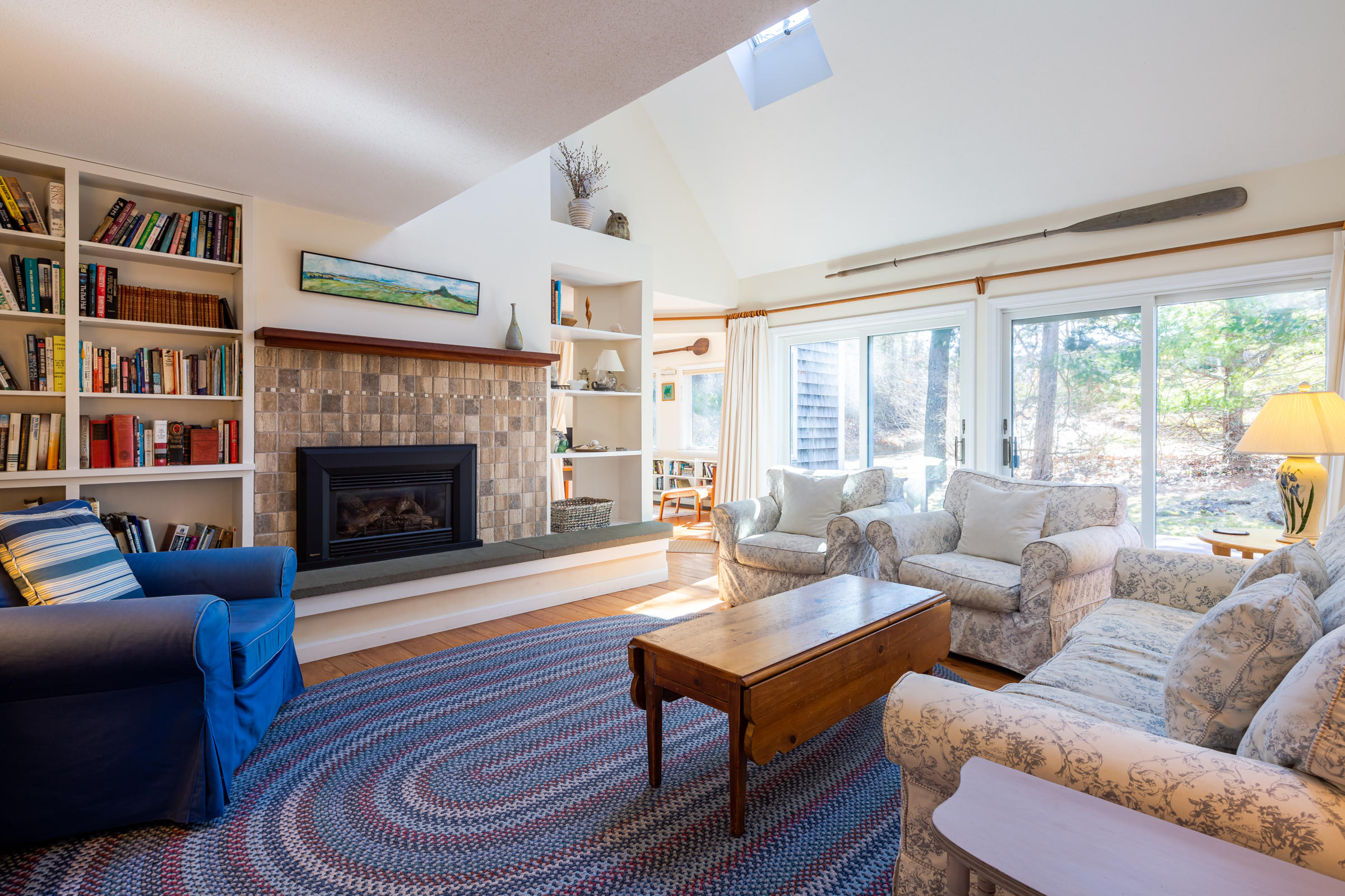 40 Chestnut Drive Orleans, MA 02653 - Photo 10 of 40 a living room with furniture a bookshelf and a fireplace