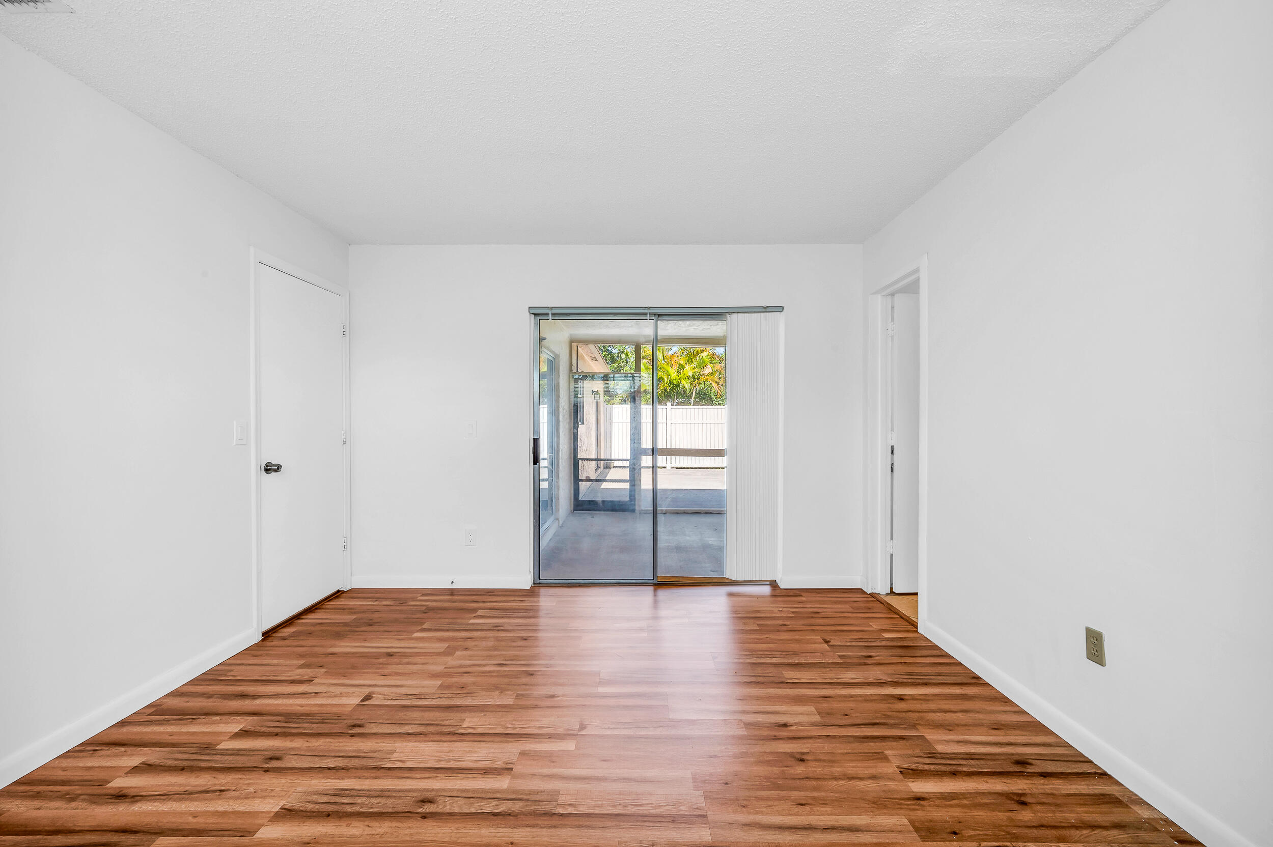 10905 Eureka Street Boca Raton, FL 33428 - Photo 4 of 16 a view of empty room with wooden floor and fan