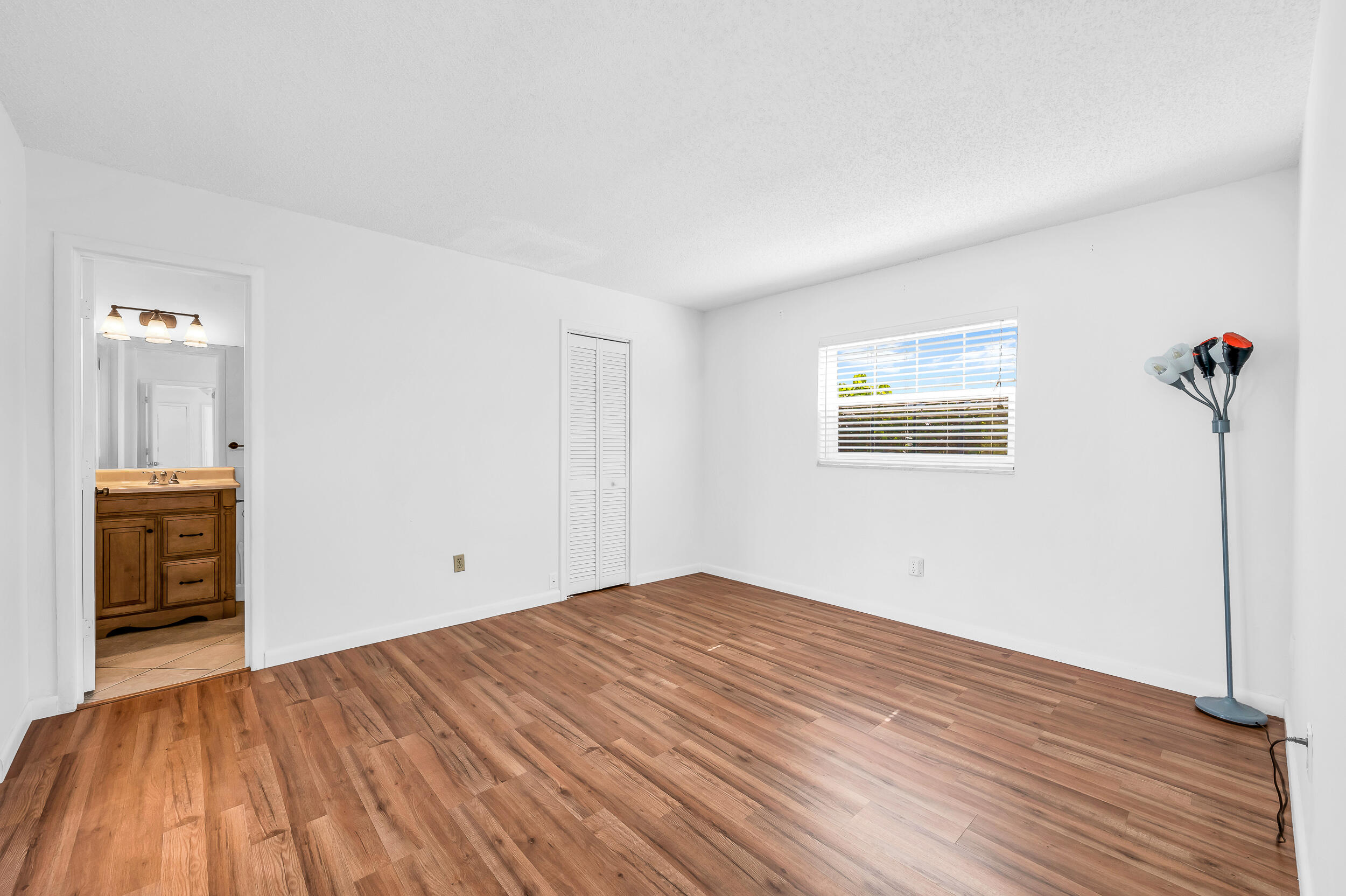 10905 Eureka Street Boca Raton, FL 33428 - Photo 5 of 16 a view of empty room with wooden floor and fan