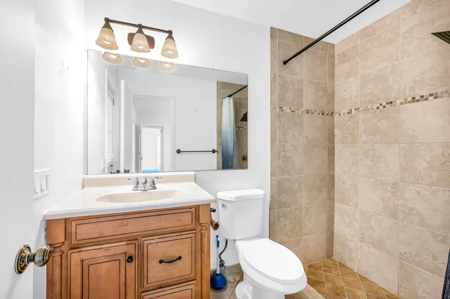 a bathroom with a sink a toilet a mirror and shower