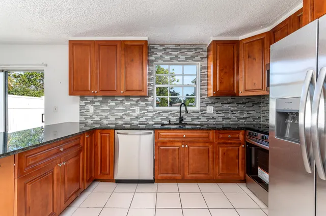 a kitchen with stainless steel appliances granite countertop a sink stove and cabinets