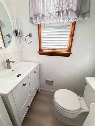 a bathroom with a sink a toilet and a mirror