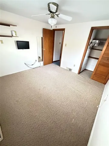 a view of an empty room with a ceiling fan