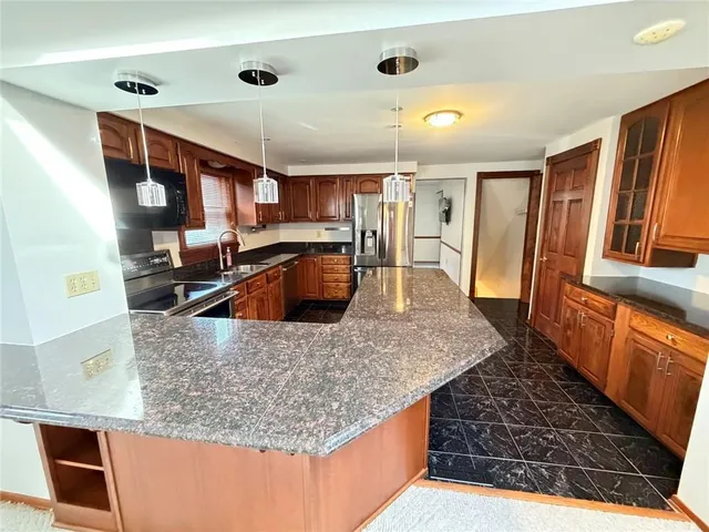 a kitchen with stainless steel appliances granite countertop a sink a stove and a refrigerator