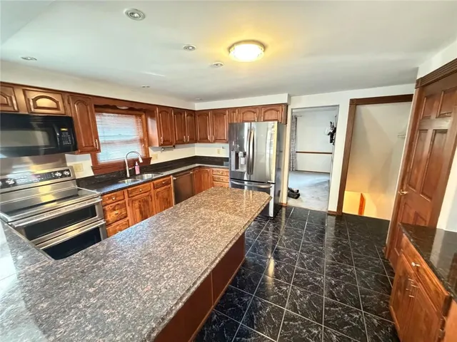 a kitchen with stainless steel appliances granite countertop a refrigerator and a sink