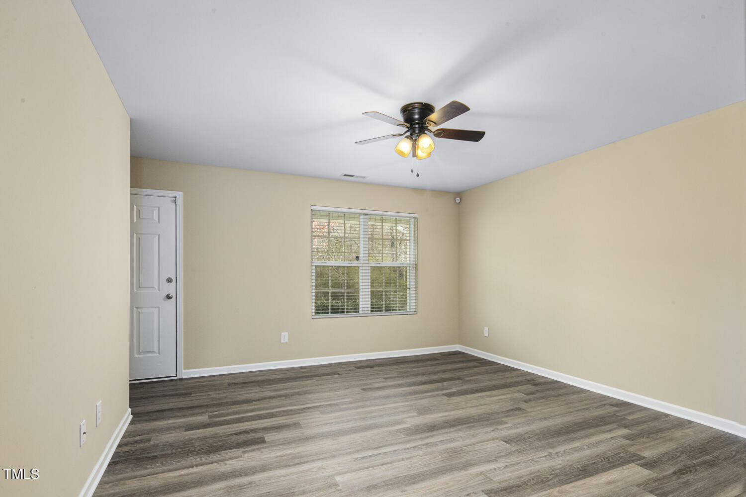 1536 Ricochet Drive Raleigh, NC 27610 - Photo 7 of 31 a view of an empty room with a window and wooden floor