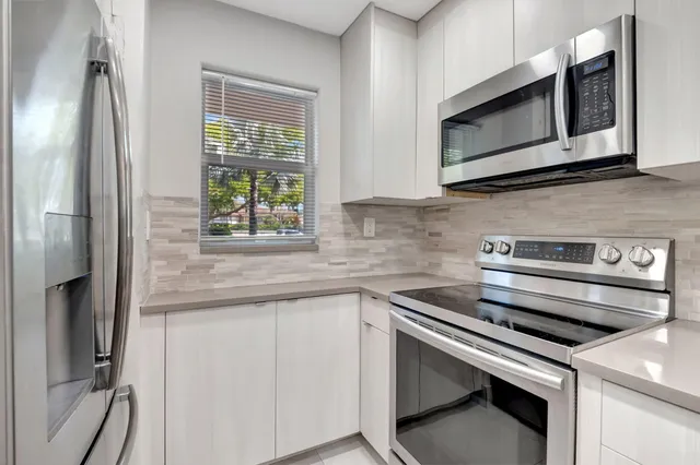 a kitchen with kitchen island a sink and a stove top oven