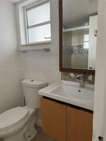 a bathroom with a toilet sink and mirror