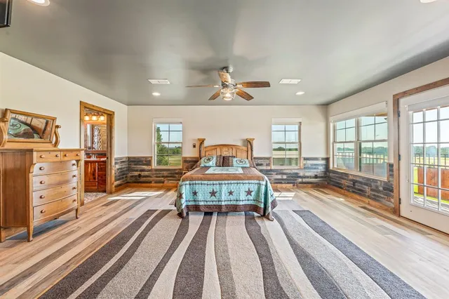 a spacious bedroom with a bed and wooden floor