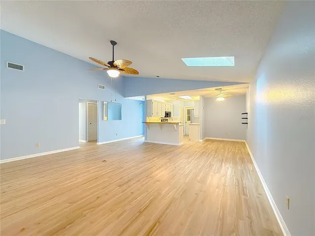 a view of empty room with wooden floor