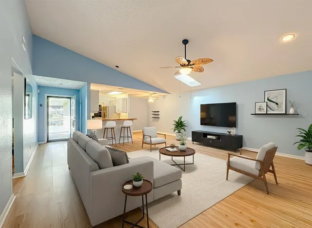 a living room with furniture a flat screen tv and a large window