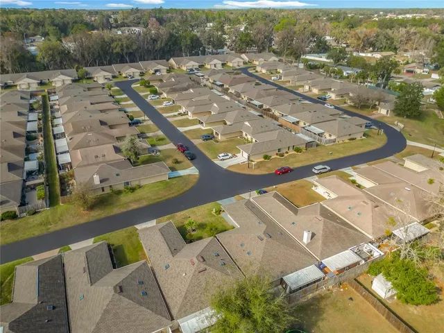 an aerial view of residential houses with outdoor space and parking