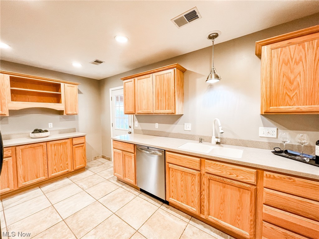 6830 Oakwood Road Parma Heights, OH 44130 - Photo 8 of 22 Kitchen featuring dishwasher, sink, light brown cabinetry, light tile floors, and hanging light fixtures