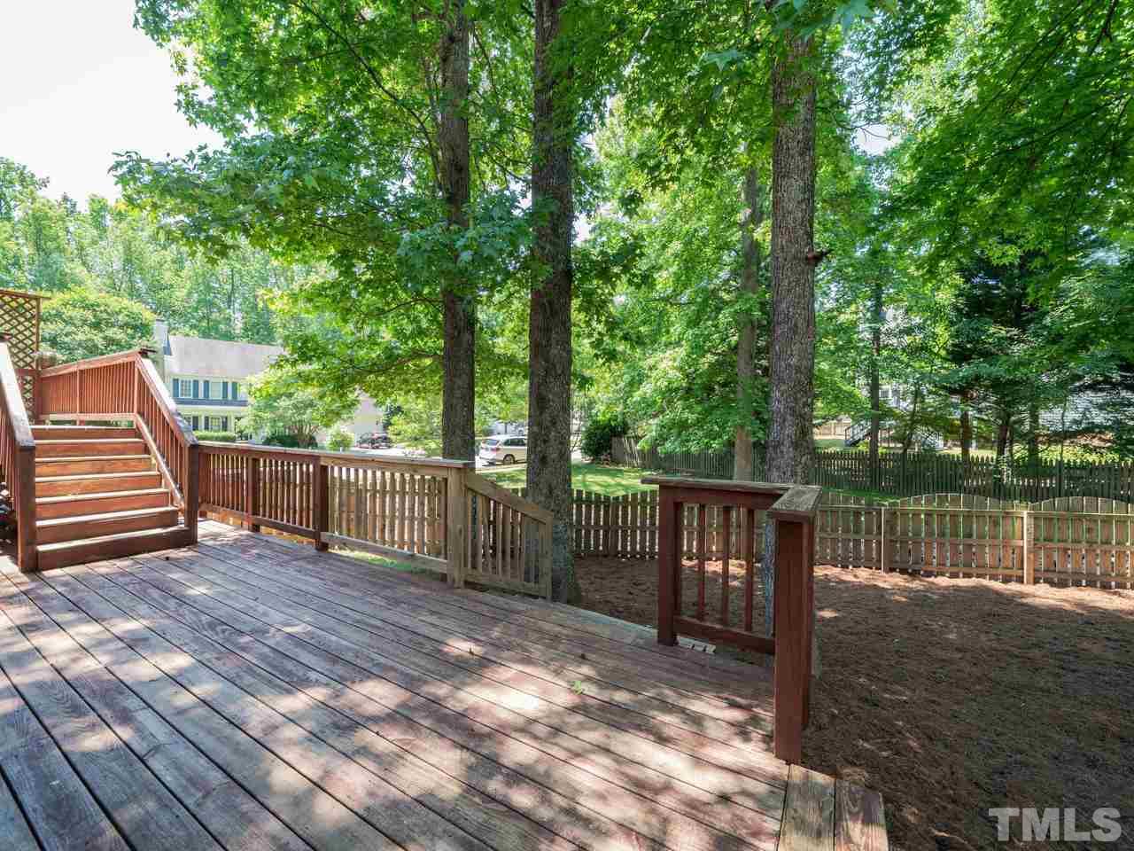 9101 Cub Trail Raleigh, NC 27615 - Photo 18 of 22 a view of a deck with a table and chairs next to a yard