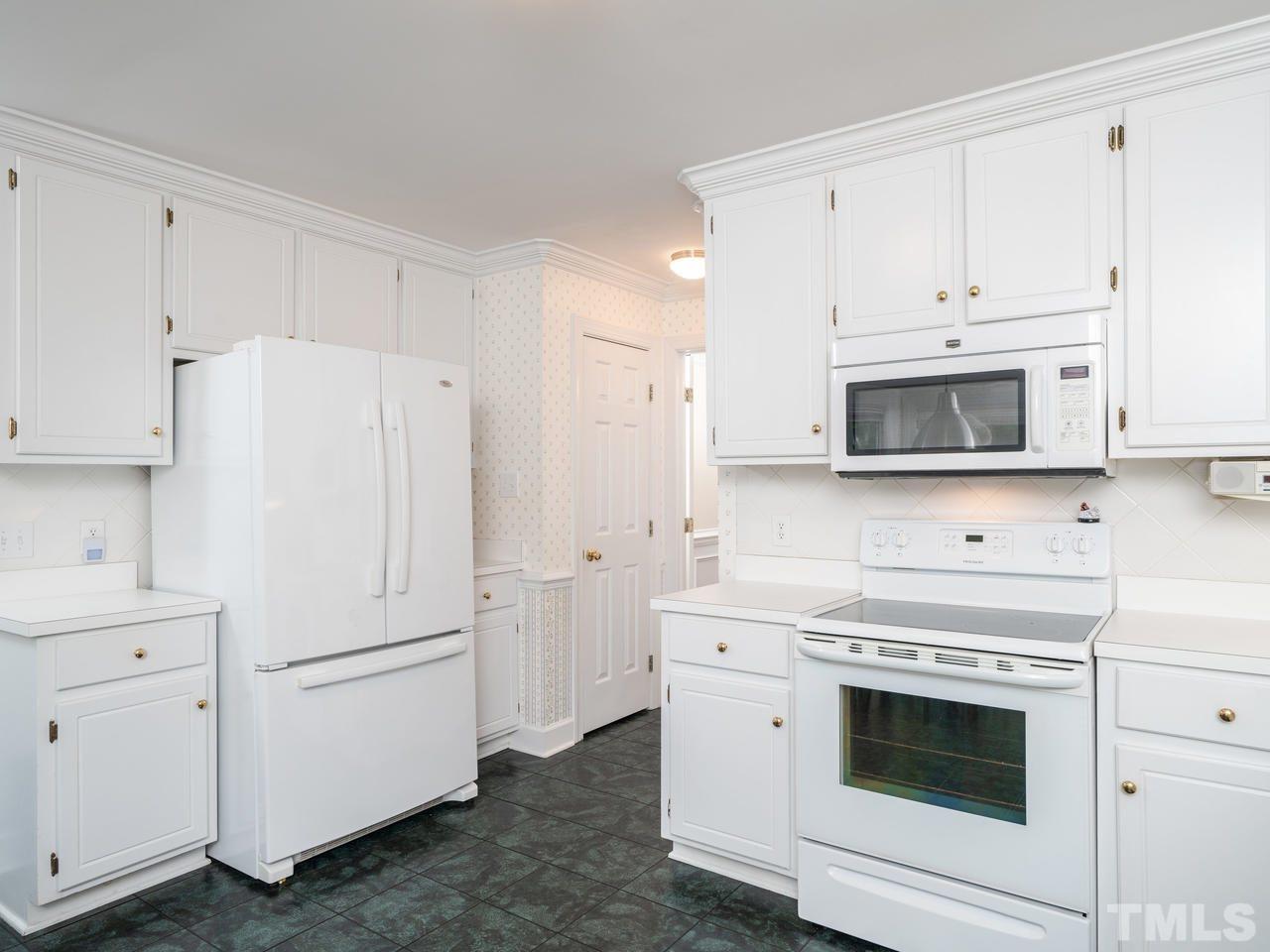 9101 Cub Trail Raleigh, NC 27615 - Photo 9 of 22 a kitchen with white cabinets and white appliances