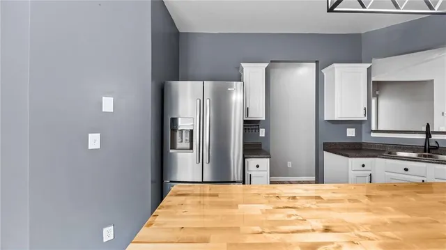 a view of a kitchen with a refrigerator and a sink