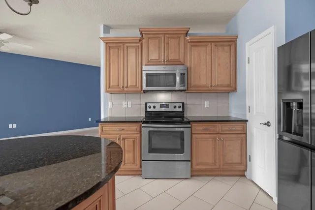 an empty room with windows and ceiling fan