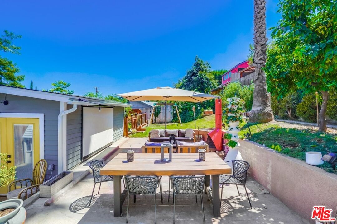6116 Springvale Drive Los Angeles, CA 90042 - Photo 22 of 33 a view of a patio with a table and chairs under an umbrella