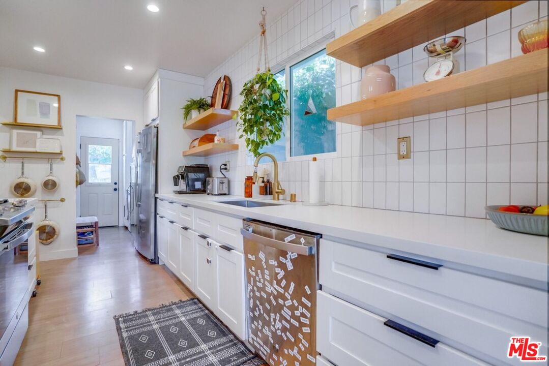 6116 Springvale Drive Los Angeles, CA 90042 - Photo 9 of 33 a kitchen with stainless steel appliances cabinets and a wooden floor