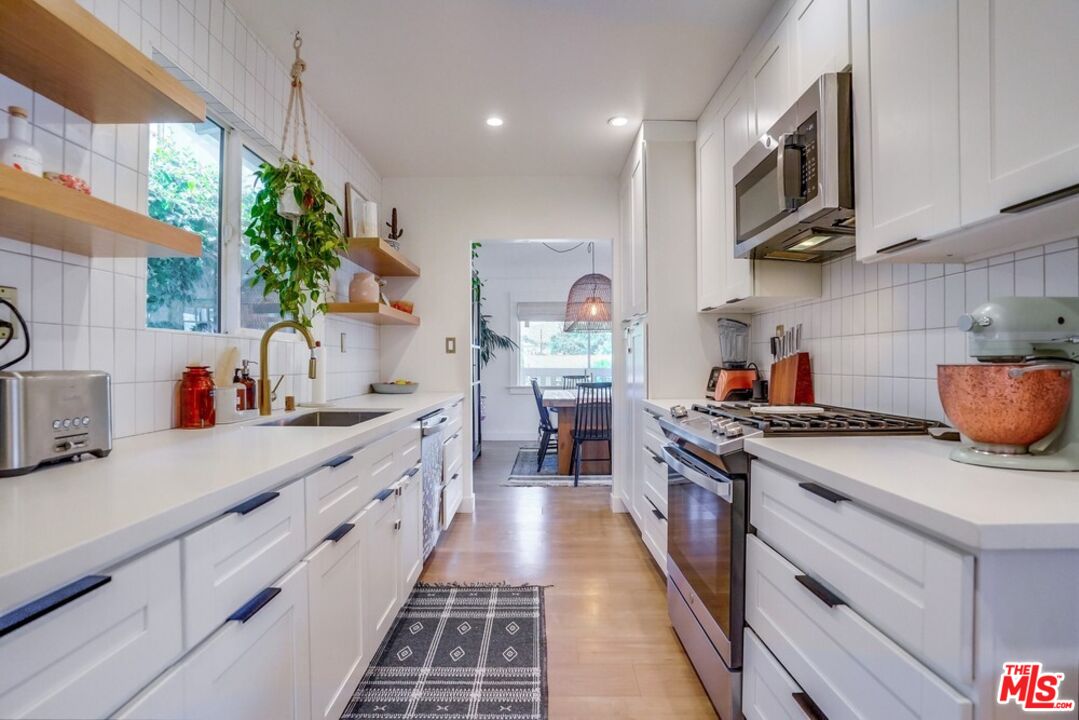 6116 Springvale Drive Los Angeles, CA 90042 - Photo 10 of 33 a kitchen with kitchen island granite countertop lots of counter top space and wooden floor