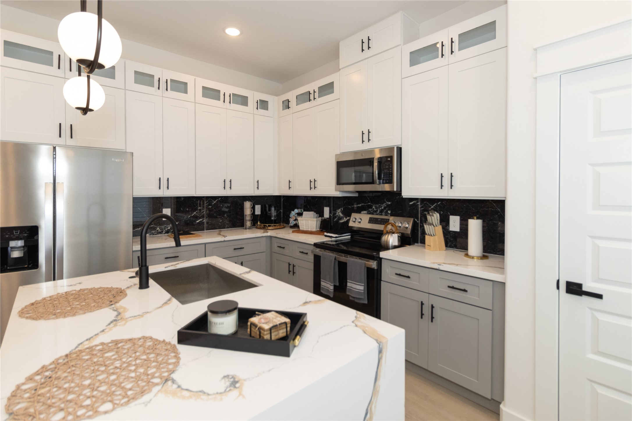 4902 Higgins Street, Unit B Houston, TX 77033 - Photo 11 of 39 a kitchen with stainless steel appliances kitchen island granite countertop a sink dishwasher a stove and a refrigerator with wooden floor