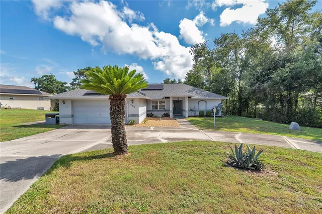 a front view of a house with swimming pool and trees