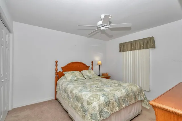 a bedroom with a bed and a ceiling fan