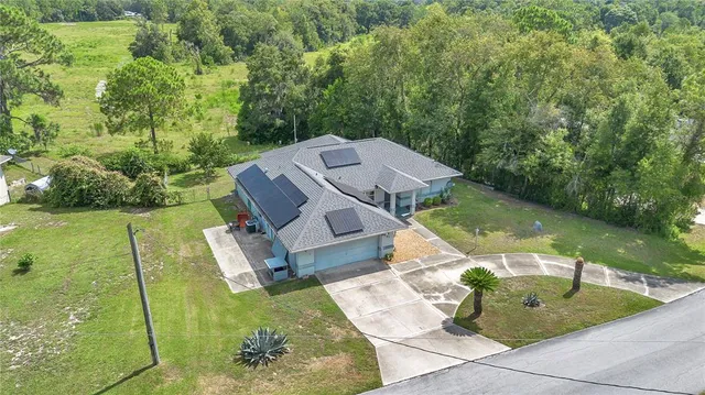 an aerial view of a house with garden space and that has swimming pool
